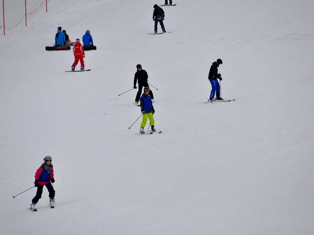 Mehrere Skifahrende verteilt auf einem flachen Pistenabschnitt.